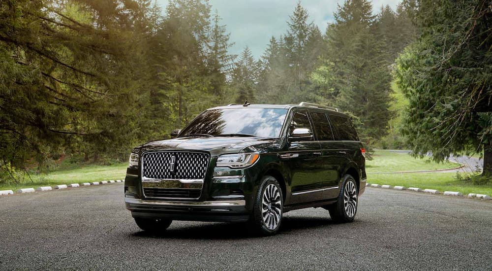 A black 2022 Lincoln Navigator is shown parked in a lot surrounded by trees.