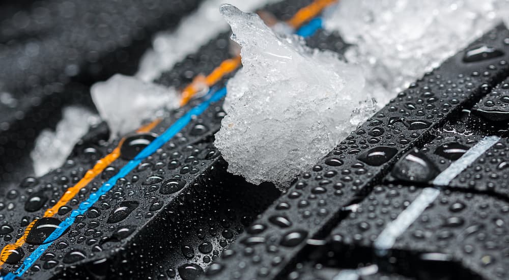A close up shows snow in the tread of a set of winter tires.