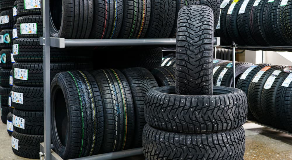 A stack of winter tires for sale are shown at a car repair shop.