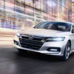 A white 2020 Honda Accord is shown from the front while driving through a city.