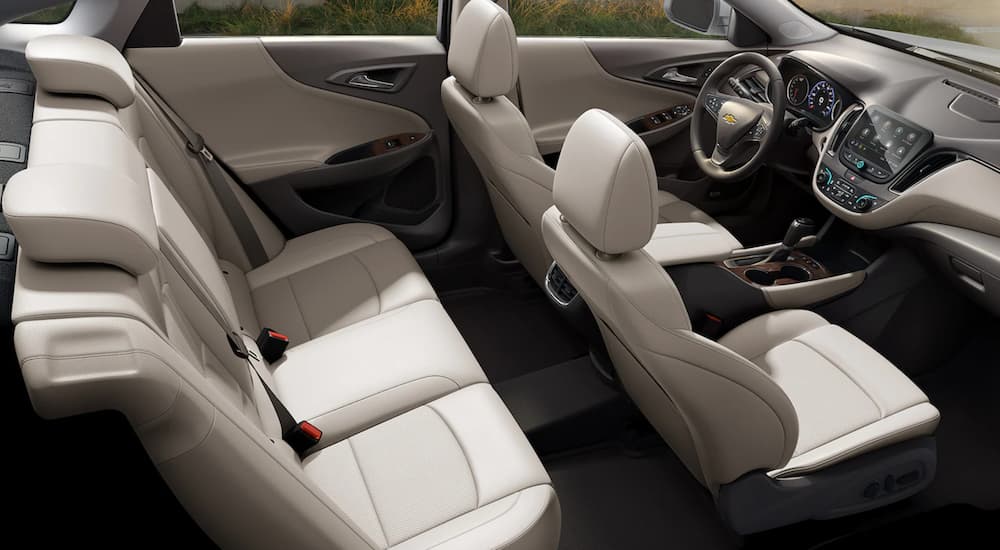 The white interior of a 2023 Chevy Malibu is shown from the passenger side at a high angle.