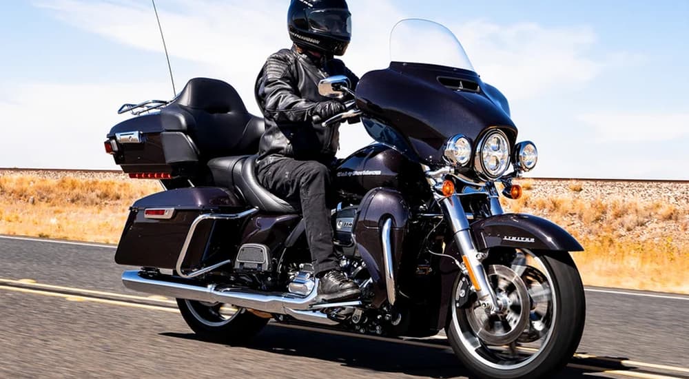 A black 2022 Harley-Davidson Ultra Limited is shown driving on an open highway.