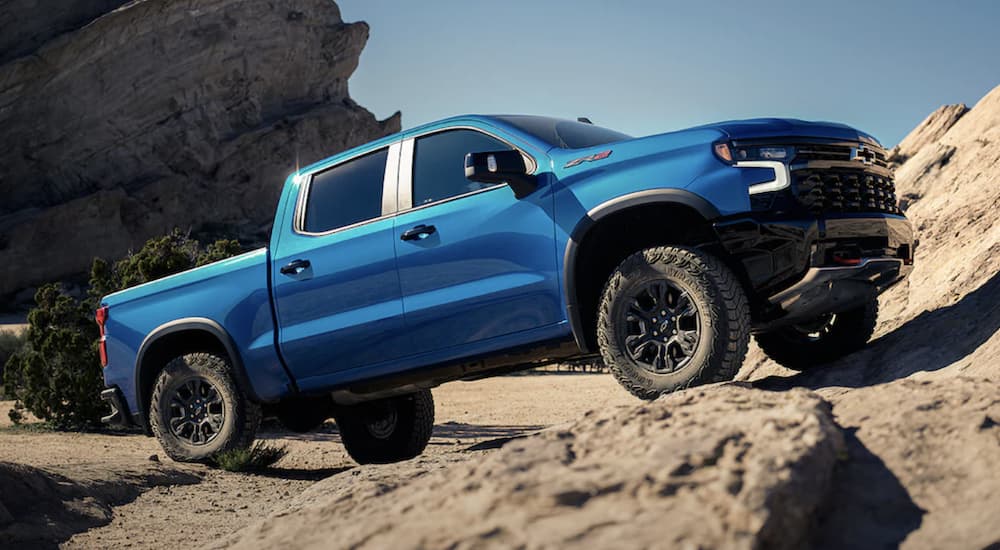 A blue 2023 Chevy Silverado 1500 ZR2 is shown parked off-road.