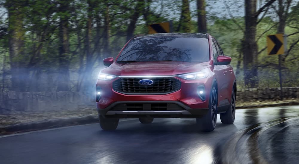 A red 2023 Ford Escape is shown driving at dusk.