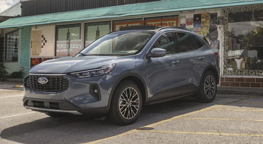 A grey 2023 Ford Escape is shown from the side parked in front of a restaurant.