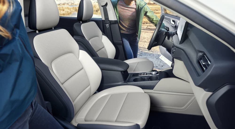 The white and black interior of a 2023 Ford Escape shows the front seats. 
