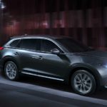 A grey 2023 Mazda CX-9 is shown driving on concrete.