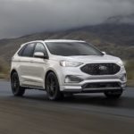 A white 2023 Ford Edge is shown driving on an open road.