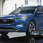 A blue 2023 Ford Escape is shown from the front parked in a gallery.