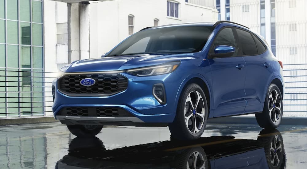 A blue 2023 Ford Escape is shown from the front parked in a gallery.