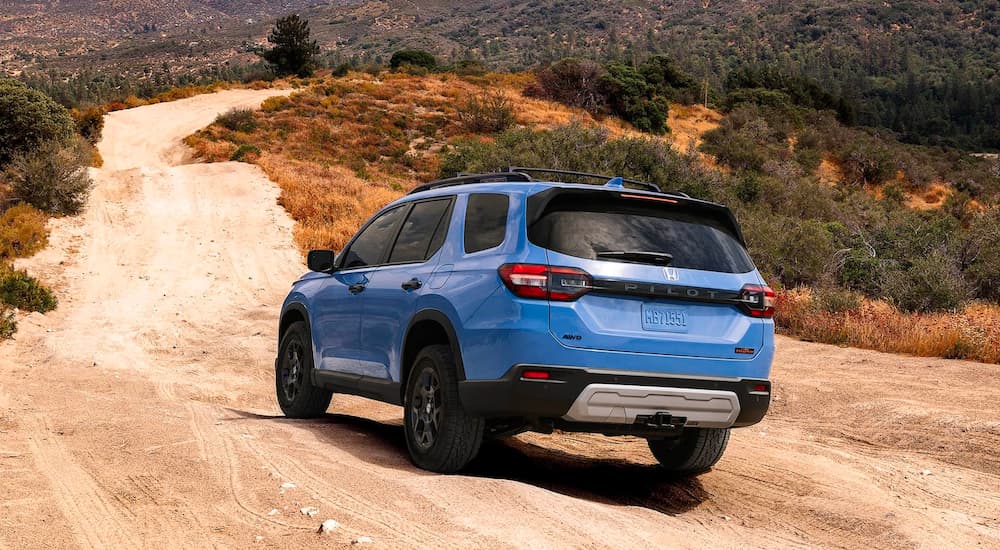 A blue 2023 Honda Pilot Trailsport is shown from the rear after looking at Honda SUVs.