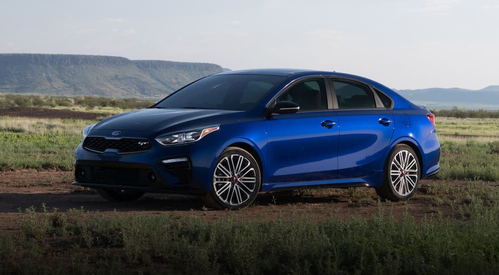 A blue 2020 Kia Forte GT is shown parked in a field.