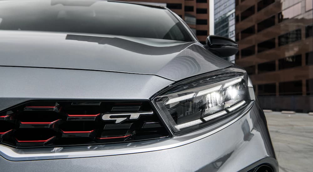 A close up of the headlight of a silver 2023 Kia Forte GT is shown.