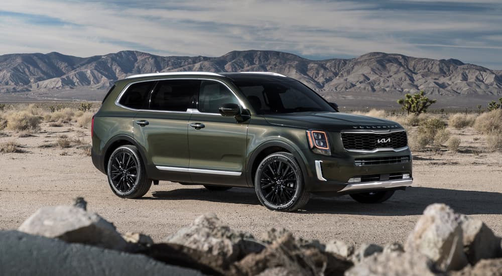 A green 2022 Kia Telluride is shown from the side parked in a desert.