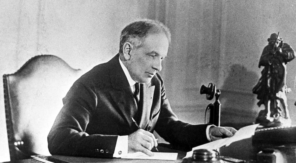 William Durant is shown at a desk in an office.