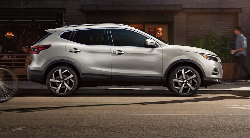 A silver 2022 Nissan Qashqai is shown from the side while parked on a city street.