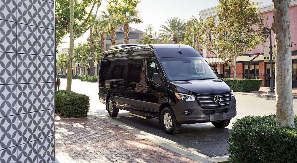 A black 2022 Mercedes Benz Sprinter, is shown parked on the side of a street.