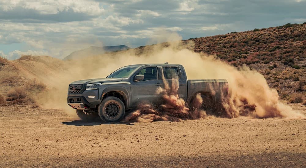 A grey 2023 Nissan Frontier Pro-4x is shown from the side while off-road.