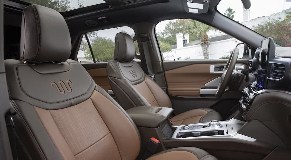The brown interior of a 2021 Ford Explorer King Ranch is shown from the passenger door opening.
