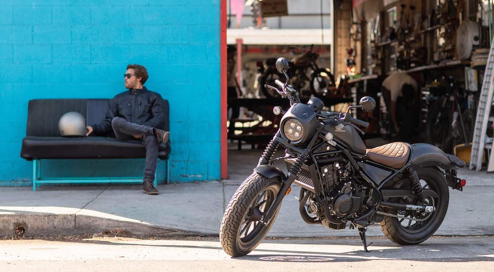 A black 2021 Honda Rebel 500 is shown from the side while parked used Honda motorcycles for sale.