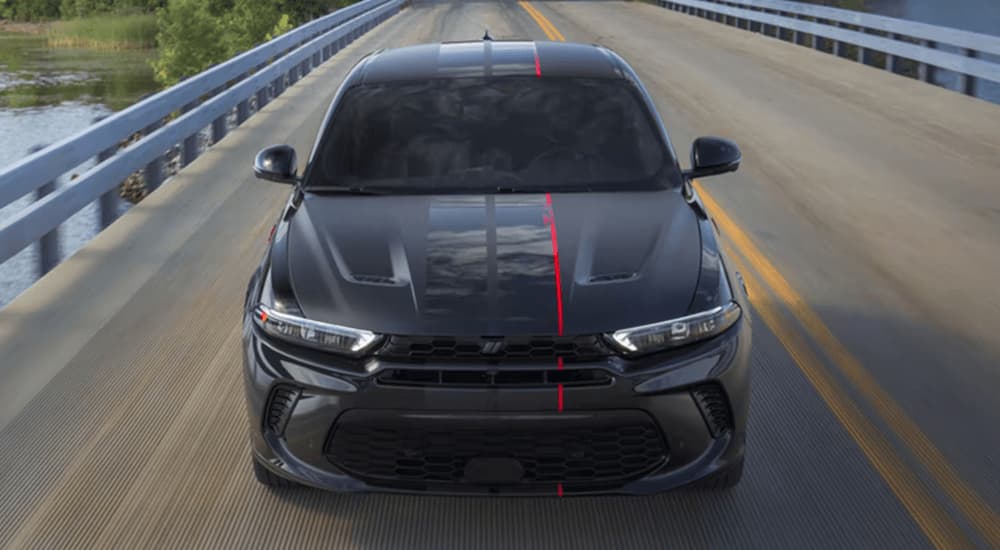 A black 2023 Dodge Hornet is shown from the front driving on a highway.