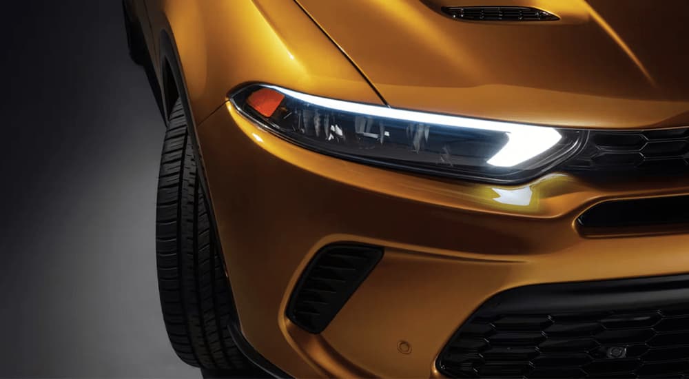 A close up of the headlight on a gold 2023 Dodge Hornet is shown during a 2023 Chevy Trailblazer vs 2023 Dodge Hornet comparison.