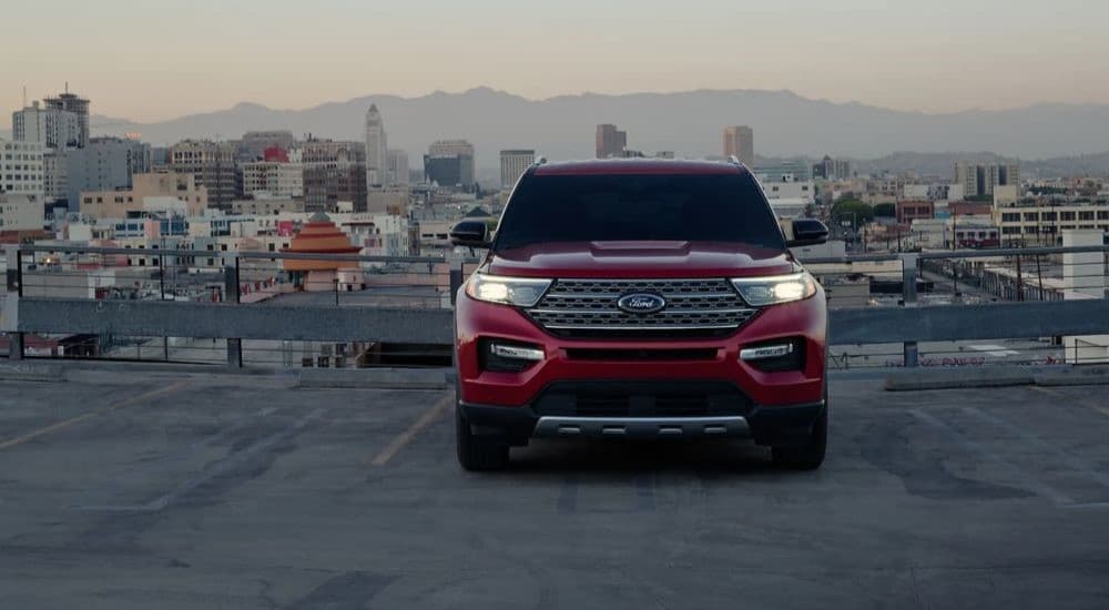 A red 2023 Ford Explorer Limited Hybrid is shown from the front on a rooftop parking garage.