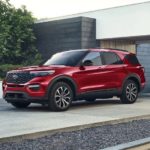 A red 2023 Ford Explorer ST-Line is shown parked on the driveway of a modern house.