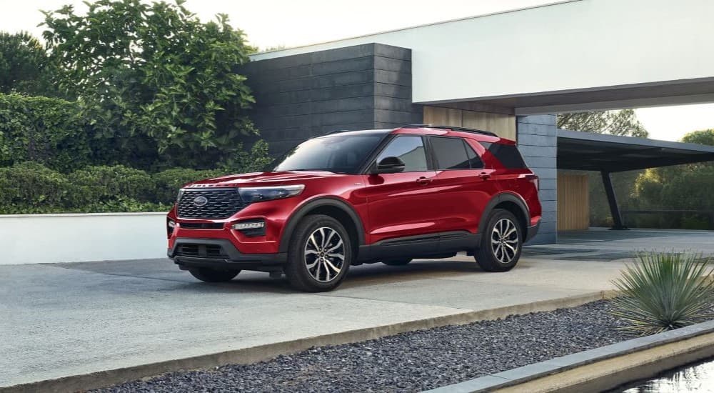 A red 2023 Ford Explorer ST-Line is shown parked on the driveway of a modern house.