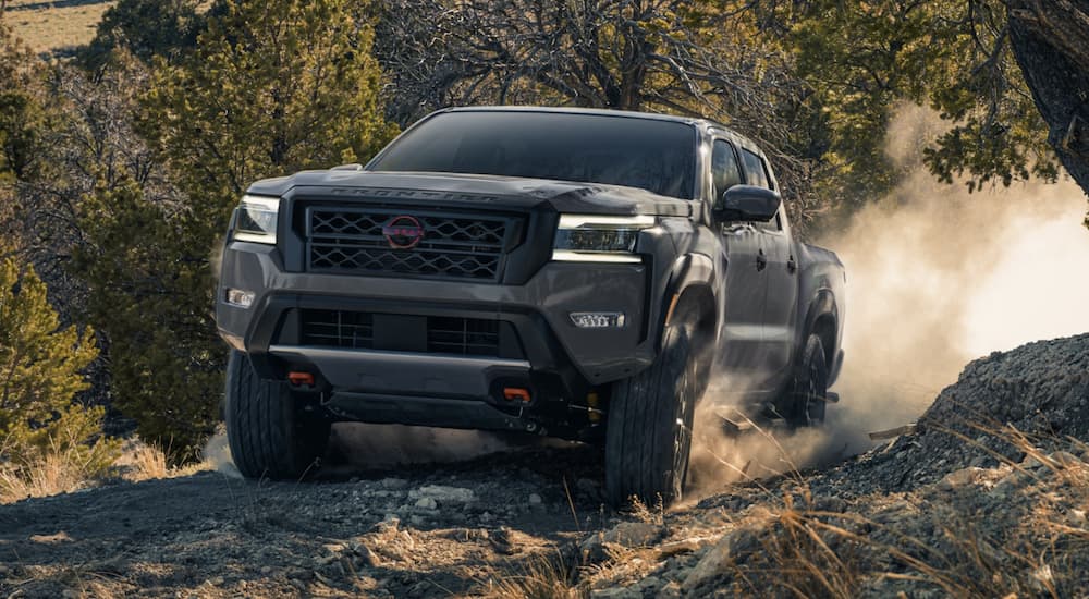 A grey 2023 Nissan Frontier Pro4x is shown from the front off-roading.