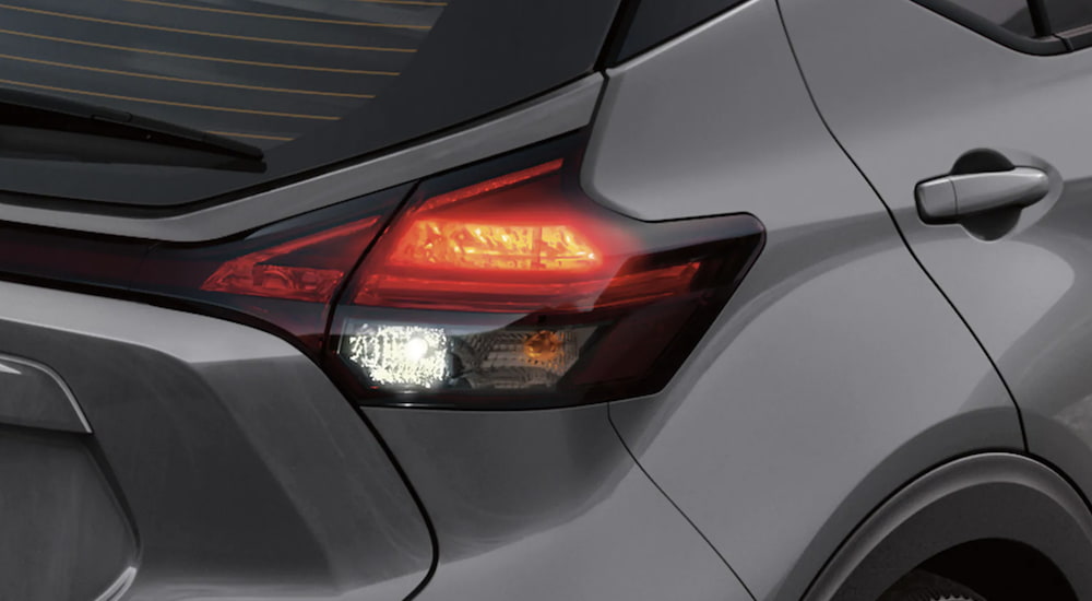The taillight of a grey 2023 Nissan Kicks is shown in close up.