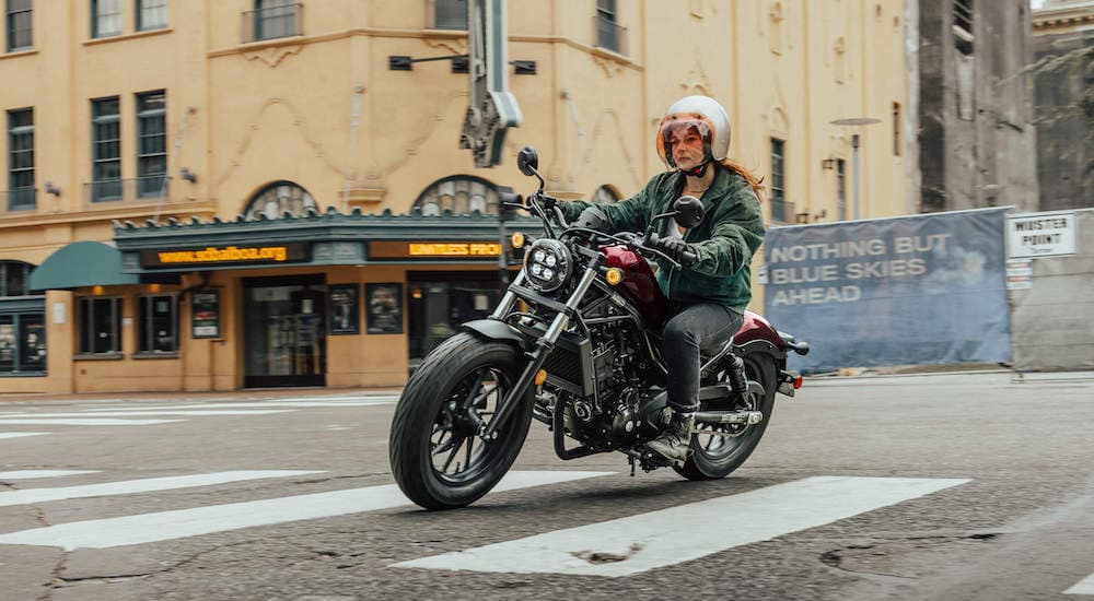 A red 2021 Honda Rebel 300 is shown from the front at an angle.