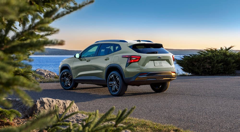 A green 2024 Chevy Trax Activ is shown from the rear parked in front of a bay.