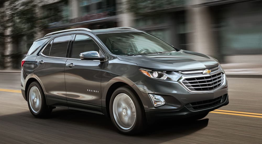 A grey 2019 Chevy Equinox is shown driving on a city street.
