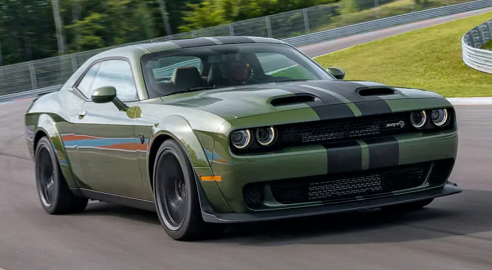 A green 2020 Dodge Challenger is shown driving on a track after leaving a Dodge Challenger dealer.