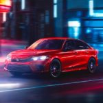 A red 2022 Honda Civic Sport is shown on a city street at night.