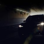 A black 2024 Mazda CX-90 is shown driving through a tunnel.