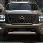 A brown 2023 Nissan Titan is shown from the front parked in an alleyway.