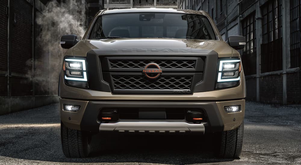 A brown 2023 Nissan Titan is shown from the front parked in an alleyway.