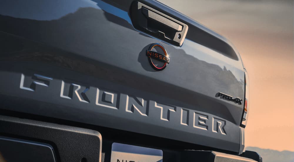 The tailgate on a grey 2023 Nissan Frontier Pro-4x is shown at a Nissan frontier dealer.