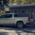 A silver 2023 Chevy Silverado 1500 Z71 is shown from the side as the bed is loaded with supplies.