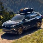 A black 2023 Toyota RAV4 Hybrid Woodland Edition is shown on a trail after leaving a Toyota RAV4 dealer.