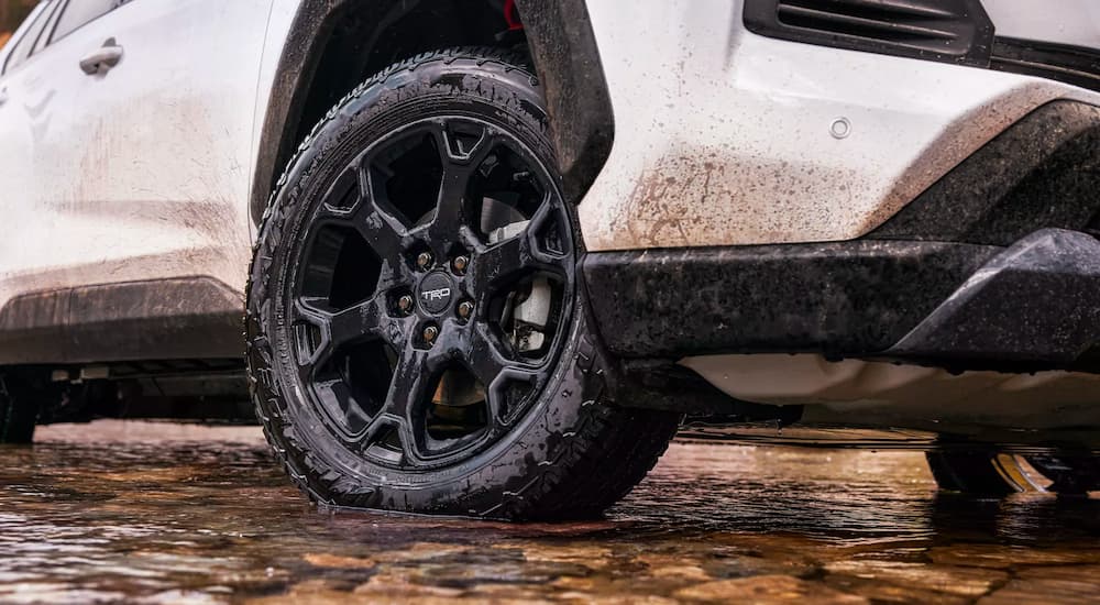 A close up shows a black rim on a white 2023 Toyota RAV4 TRD Off-Road.