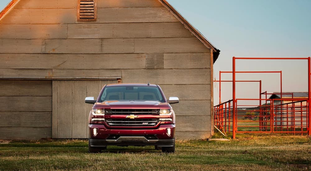 A maroon 2016 Chevy Silverado Z71 1500 is shown in front of a barn.