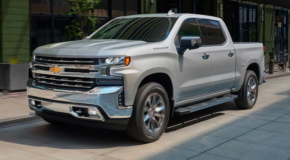 A silver 2019 Chevy Silverado 1500 is shown driving on a city street.