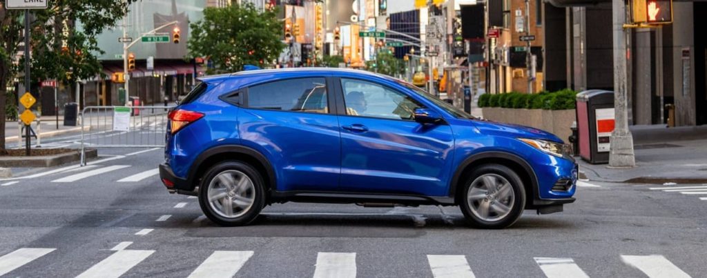 A blue 2020 Honda HR-V EX-L is shown on a city street after looking at used Honda SUVs.