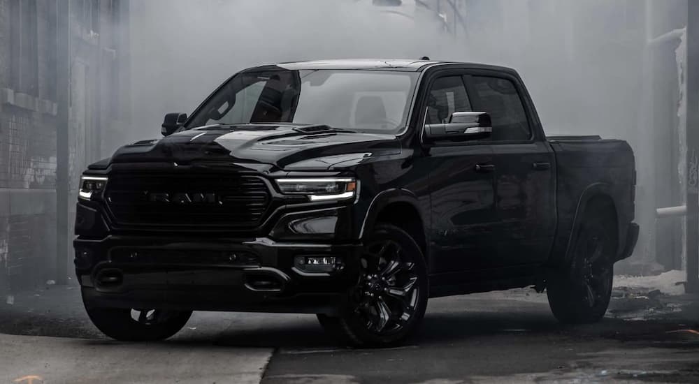 A black 2023 Ram 1500 is shown from the side parked in an alleyway.