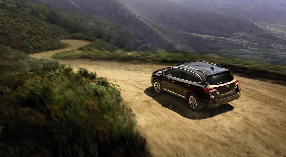 A black 2017 Subaru Outback is shown from a high angle on a mountain trail.