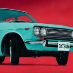 A teal 1970 Datsun 510 is shown from the front on a red background.
