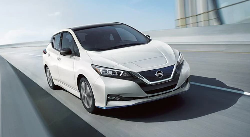 A white 2021 Nissan LEAF is shown from the front at an angle after leaving a Nissan dealer.